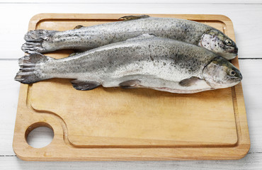 Two rainbow trouts on rustic wooden table.