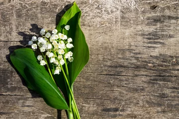 Wall murals Lily of the valley Lily of the valley flowers on wooden background with copy space. Top view