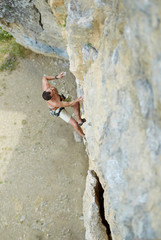 adult man rock climber. rock climber climbs on a rocky wall. man makes hard move