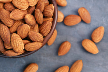 Almonds in bowl on grey wooden table