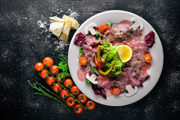 Carpaccio of beef, vegetables, cheese, spices, to Wooden background. Top view. Free space