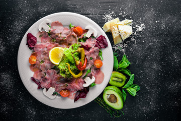 Carpaccio of beef, vegetables, cheese, spices, to Wooden background. Top view. Free space