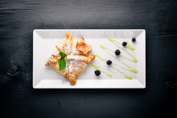 Strudel with apples and berries. On a wooden background. Top view. Free space for your text.