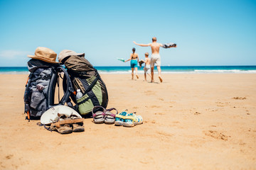 Active vacation concept image. Backpacker travelers family happy to swim in ocean waves