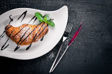 Croissant. On a wooden background. Top view. Free space for your text.