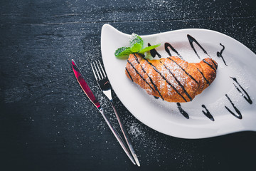 Croissant. On a wooden background. Top view. Free space for your text.