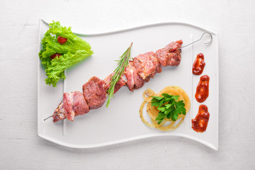 Raw shish kebab On a wooden background. Top view. Free space for your text.