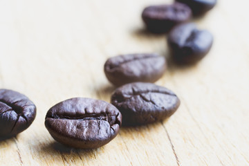 Coffee beans on wooden table.