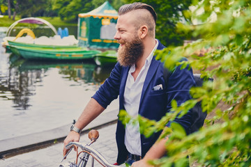 A man on a retro bicycle in a park.