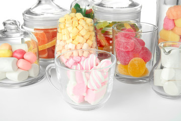 Colorful candies in glassware on white background, close up