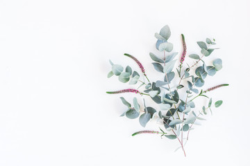 Flowers composition. Pattern made of pink flowers and eucalyptus branches on white background. Flat...