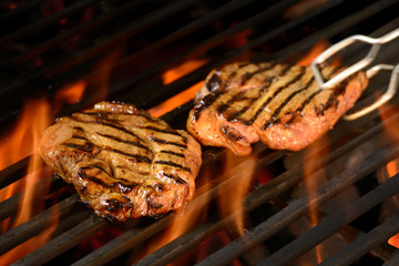 Grilled pork steak on the flaming grill
