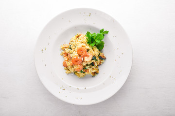 Risotto with shrimp. On a wooden background. Top view. Free space for your text.