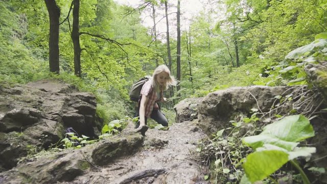 blonde woman travel in nature mountain with backpack