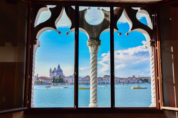 Fototapeta premium Spektakularny widok na Wenecję z typowego weneckiego okna. Miasto przygotowuje się do Redentore. Głównymi tematami są dzwonnica św. Marka, bazylika i kanał Giudecca