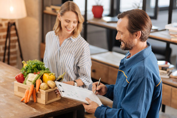 Lively motivated courier checking the delivery