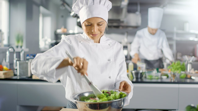 In a Famous Restaurant Female Cook Prepares Salad. She Works in a Big Modern Kitchen.
