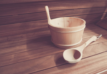 Wooden Bathhouse with scoop and tub tools close up. Wooden sauna interior with equipment.