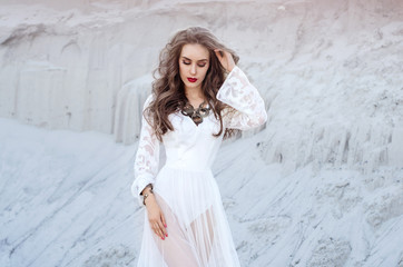 Fototapeta na wymiar Attractive young woman in white long dress in the desert. Boho S