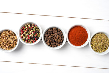 Herbs and spices in white bowls. Food background