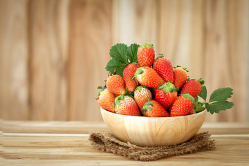 Fresh Red Strawberries in a wooden Bowl on wood background