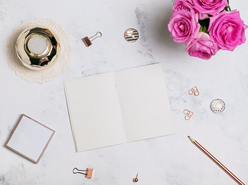 Blank notepad, pink roses and small golden accessories