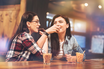 Positive delighted girls drinking tasty liqueur