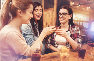 Beautiful females posing with glasses of alcohol