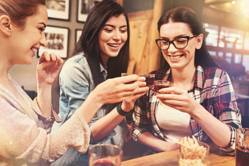 Smiling girls going to drink tasty alcohol