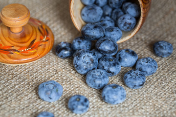 Blueberries sprinkled from rustic cup
