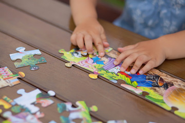 Child playing with puzzle. Child's hands closeup