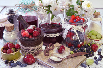 Recipe book with spoon of sugar and jars of fresh berry and homemade jam