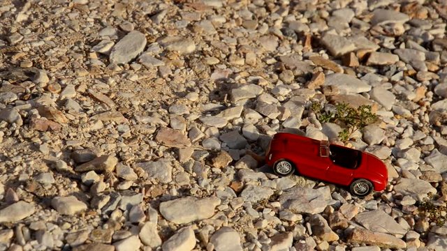 Toy car travels on pebbles