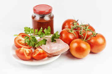 Tomato paste in a jar and tomatoes on white background