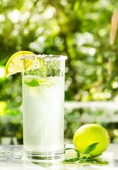 Fresh cool lemonade with mint and lime. Splash and bubbles on glass. Food photo concept