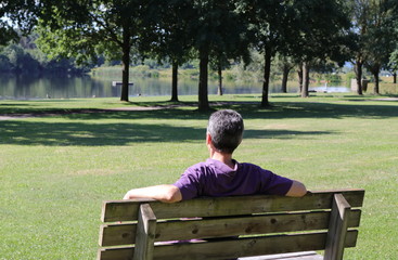 Mann sitzt entspannt am See