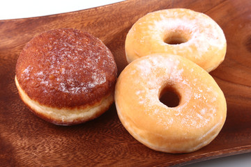 Assorted Homemade Doughnuts with Jelly filled and powdered sugar on wooden salver. Selective focus.