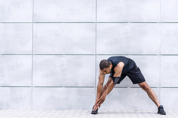 african american runner stretching on street