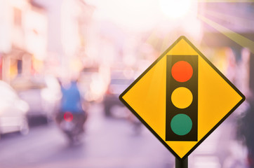 Traffic light warning sign on blur traffic road with colorful bokeh light abstract background.