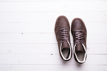 brown leather shoes with laces on wooden background with empty text space