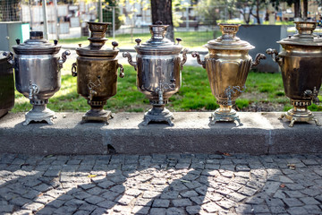 Old brass samovars sitting on the street waiting to be sold