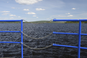 Opening in a blue railing closed with chains