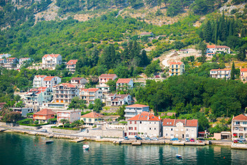 Fototapeta na wymiar Picturesque view of houses along the waterfront at the bay of Kotor, Montenegro.