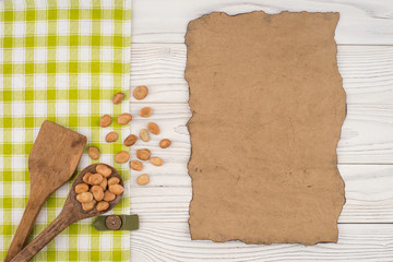 Beans in a wooden spoon on old wooden table.