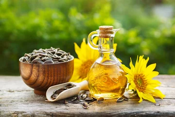 Gardinen Organic sunflower oil in a small glass jar with sunflower seeds and fresh flowers. Outdoors © valya82