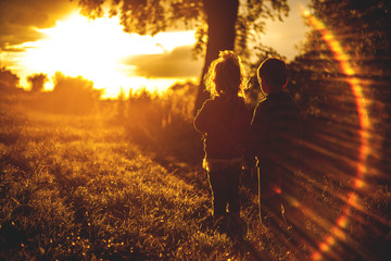 Silhouette two kids Children near tree on Sunset, romantic scene