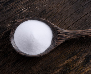 Baking Soda in spoon on wooden background