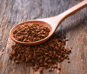 Coffee powder in spoon  on table wooden background