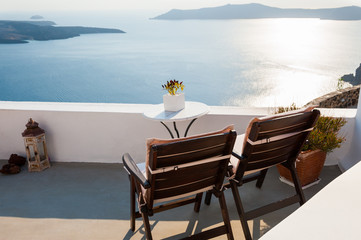 Two chairs on the terrace, sea view. Santorini island, Greece. Travel and vacation