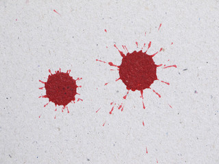 Splattered red ink stains on an old paper texture background